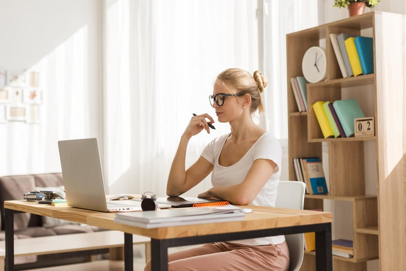 blond girl sitting at home office desk working