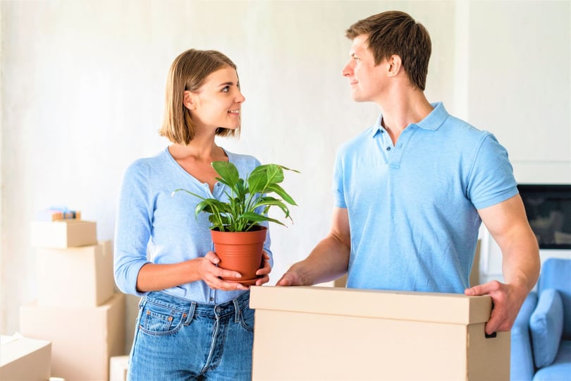 couple with plant and box ready to move out